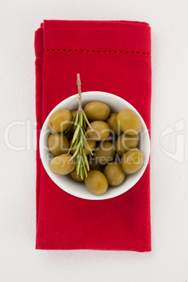 Overhead view of olives in bowl on napkin