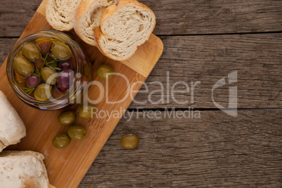 Close up of olives in container by bread