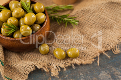 Green olives with rosemary in wooden container
