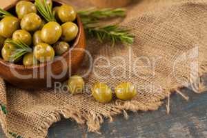 Green olives with rosemary in wooden container