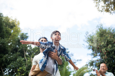 Low angle view of man looking at father playing with son