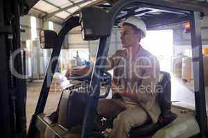 Worker driving forklift