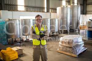 Portrait of happy technician standing with arms crossed