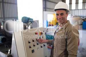 Portrait of happy technician operating a machine