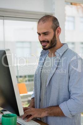 Smiling designer using computer in studio