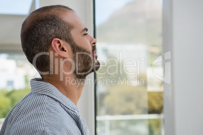 Thoughtful designer looking through window while