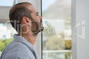 Thoughtful designer looking through window while