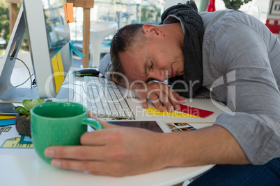 Tired businessman sleeping at desk in studio