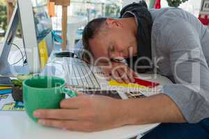 Tired businessman sleeping at desk in studio