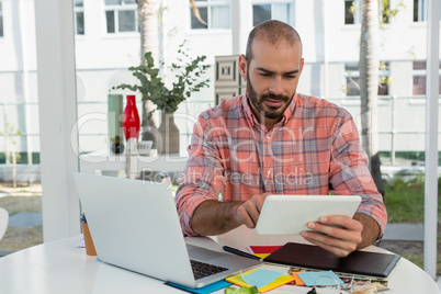 Graphic designer using tablet while sitting at desk