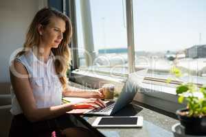 Young businesswoman working while using laptop