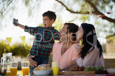 Family taking selfie on mobile phone in park