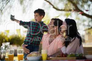 Family taking selfie on mobile phone in park
