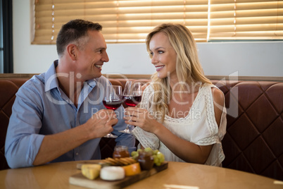 Happy couple toasting wine glass while having meal