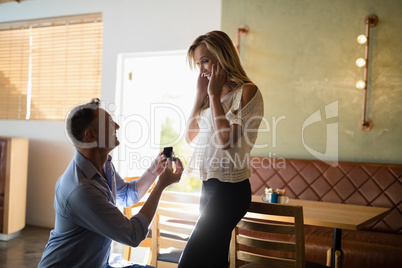Man giving engagement ring to surprised woman