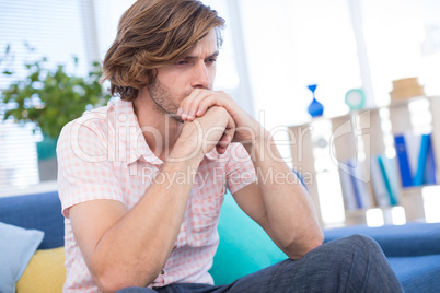 Depressed male executive sitting on sofa