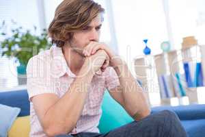 Depressed male executive sitting on sofa