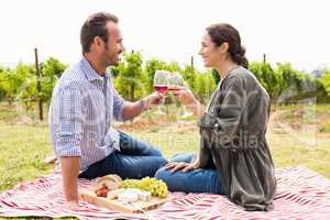 Smiling couple toasting red wineglasses