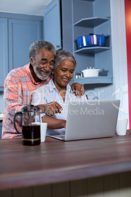 Smiling couple using laptop