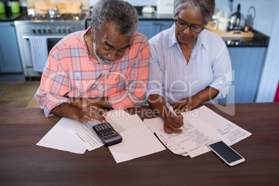 High angle view of couple using calculator