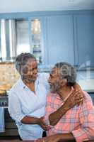 Happy couple talking in kitchen