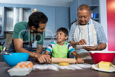 Man using table while standing by father and son preparing food