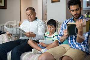 Boy with grandfather and father sitting on sofa