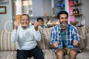 Family clenching fist while watching soccer match