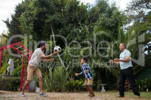 Happy family playing soccer at park