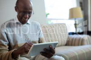 Smiling senior man using tablet