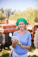 Portrait of happy woman using digital tablet in olive farm