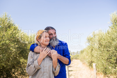 Thoughtful couple standing in olive farm