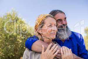 Thoughtful couple standing in olive farm