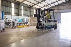 Worker carrying package with forklift