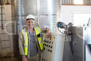 Portrait of happy technician standing near machine