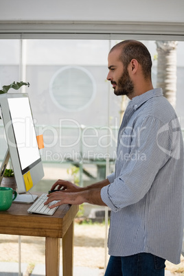 Side view of male designer using computer in studio