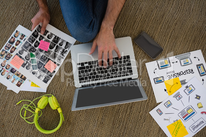 Cropped hands of designer with collage using laptop