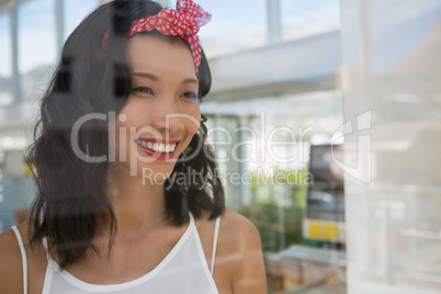 Smiling thoughtful businesswoman looking through at office