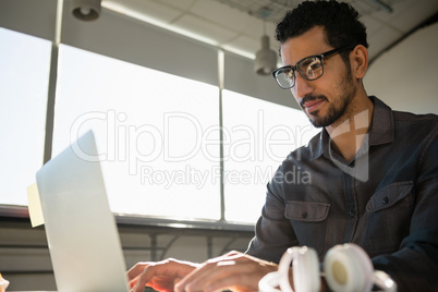 Businessman using laptop while sitting at desk