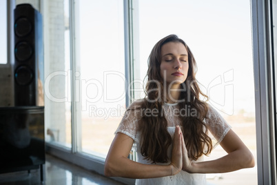Young woman doing yoga at office