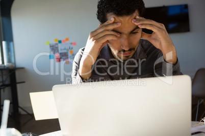 Frustrated businessman looking at laptop