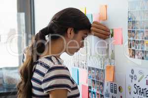 Tired businesswoman by sticky notes at office