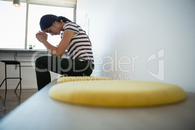 Side view of tired woman on seat in office