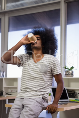 Young man drinking coffee at office