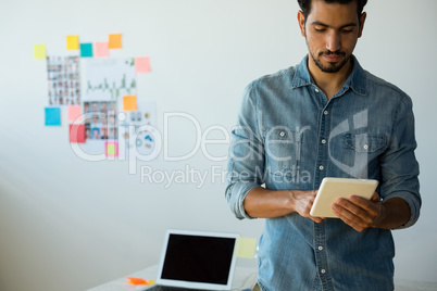 Young man using digital tablet at office