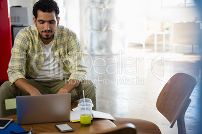 Young man using laptop at office