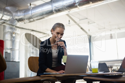 Young businesswoman using laptop in office