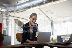 Young businesswoman using laptop in office
