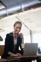 Portrait of young woman using laptop in office