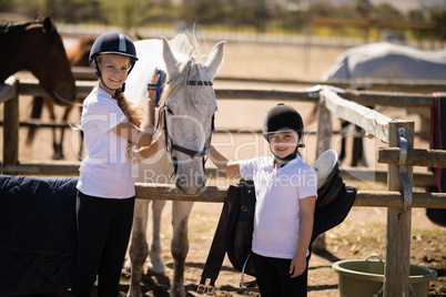 Girls grooming the horse in the ranch